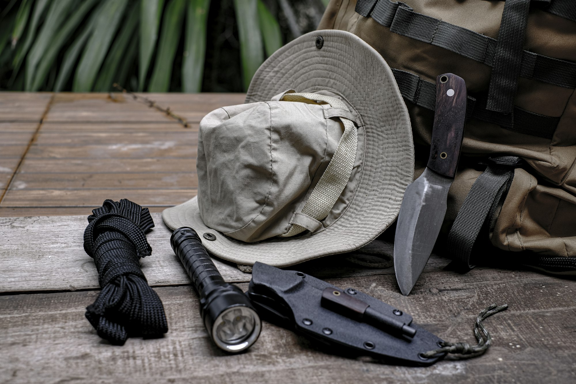 A knife with equipment for survival in the forest on an old wooden floor